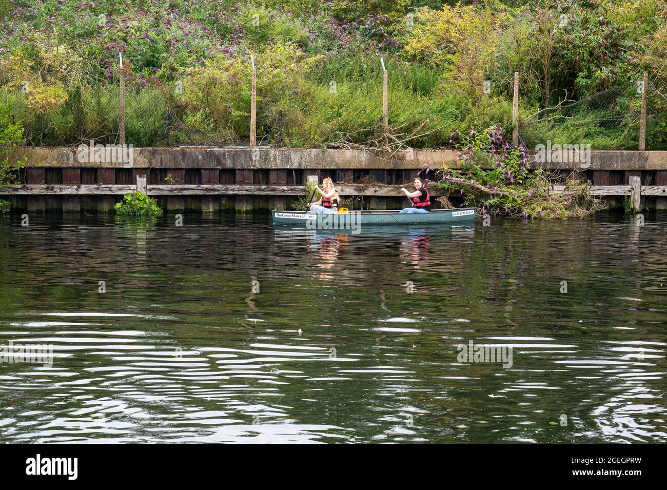 Two girls using a Canoe man hire boat on the River Yare near Norwich Stock Photo