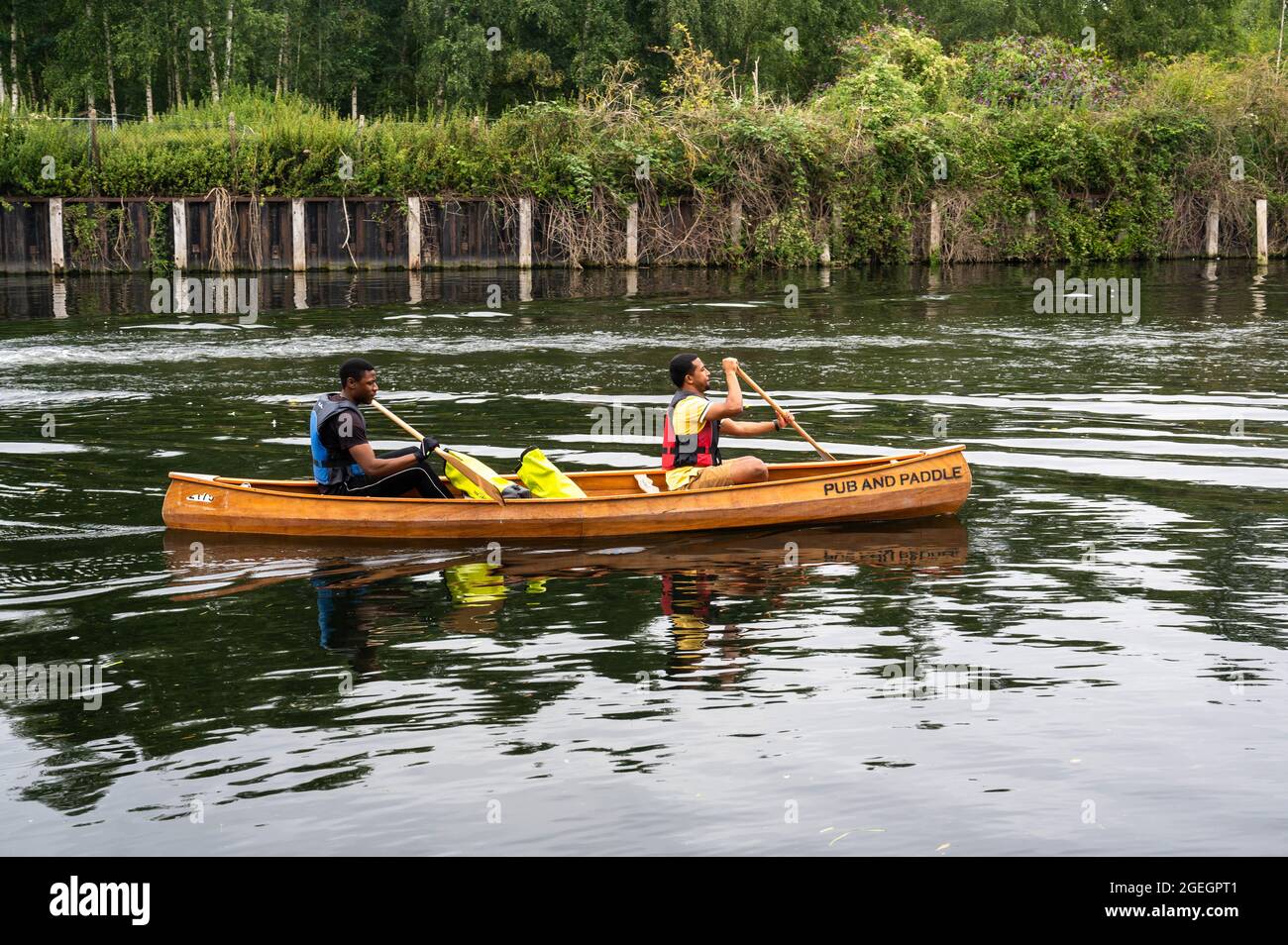 Two men in a Canoe paddling down the River Yare near Norwich Stock
