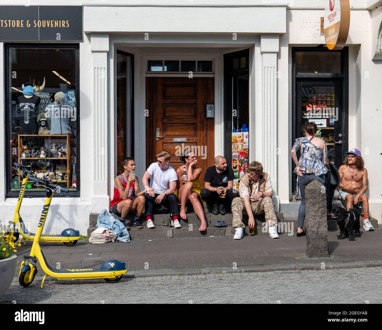 Hipster Hangout, group of friends hanging out in front of a store in Reykjavik, Iceland Stock Photo