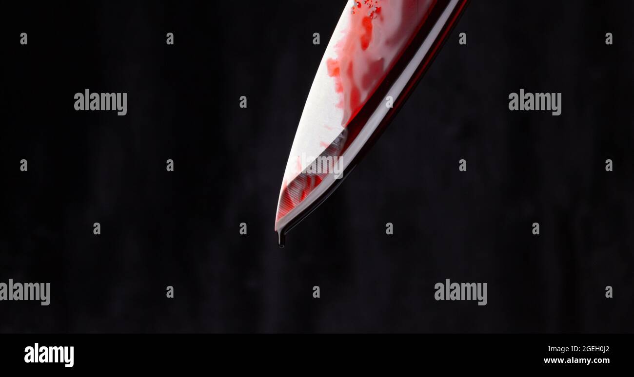 A bloody knife on a black background. The concept of murder, crime. Stock Photo