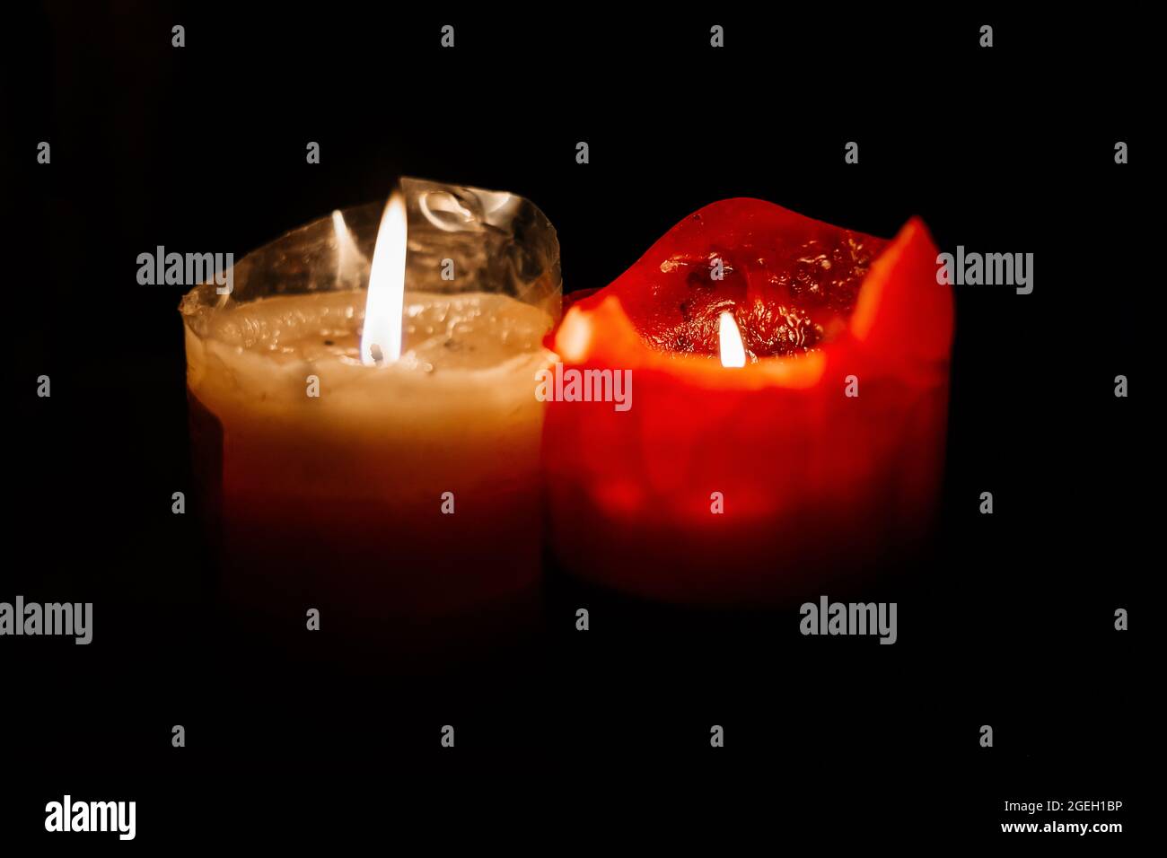 light candle burning brightly in the black background. Candle flame