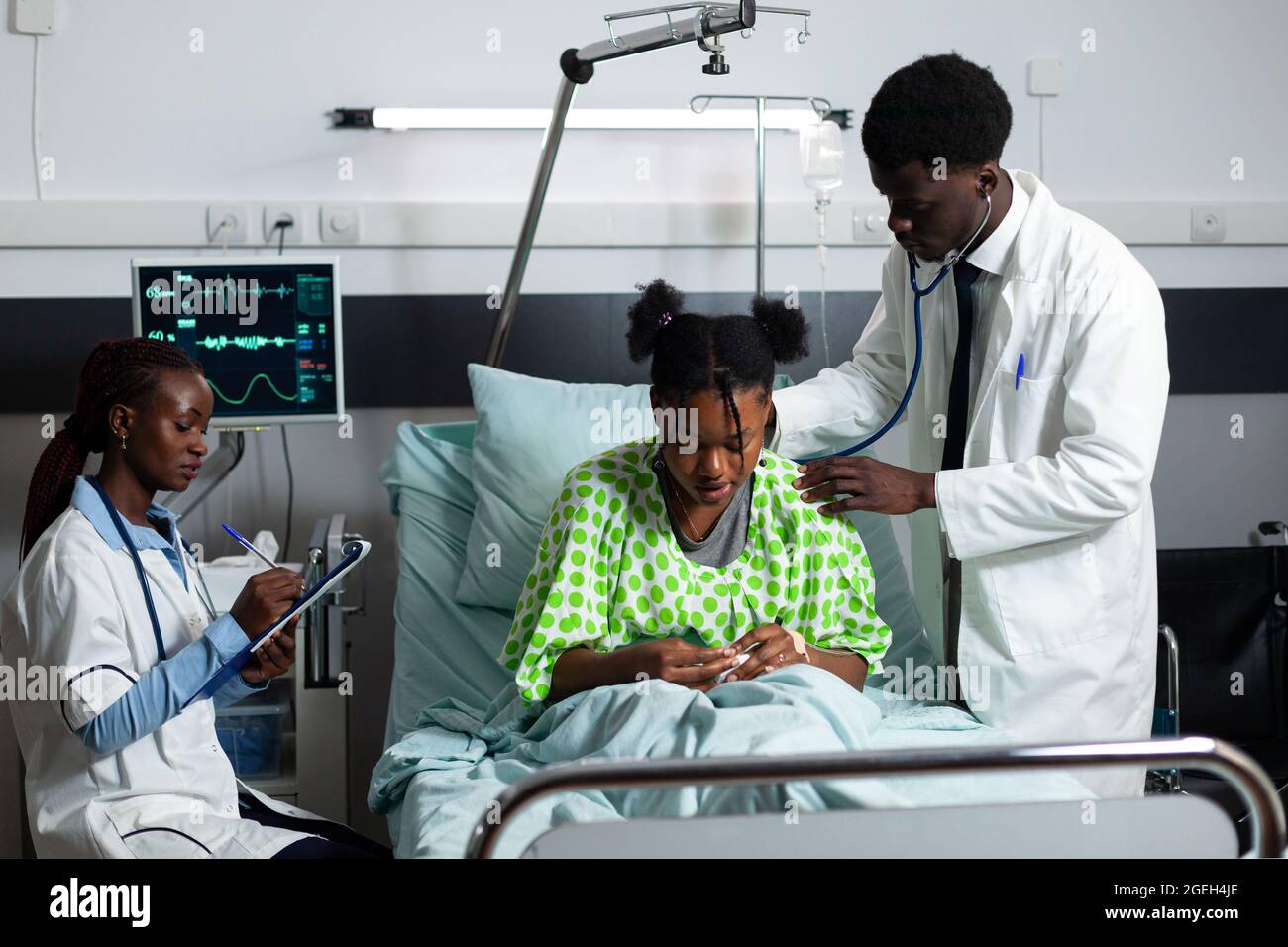 African american doctor consulting young patient in hospital ward bed