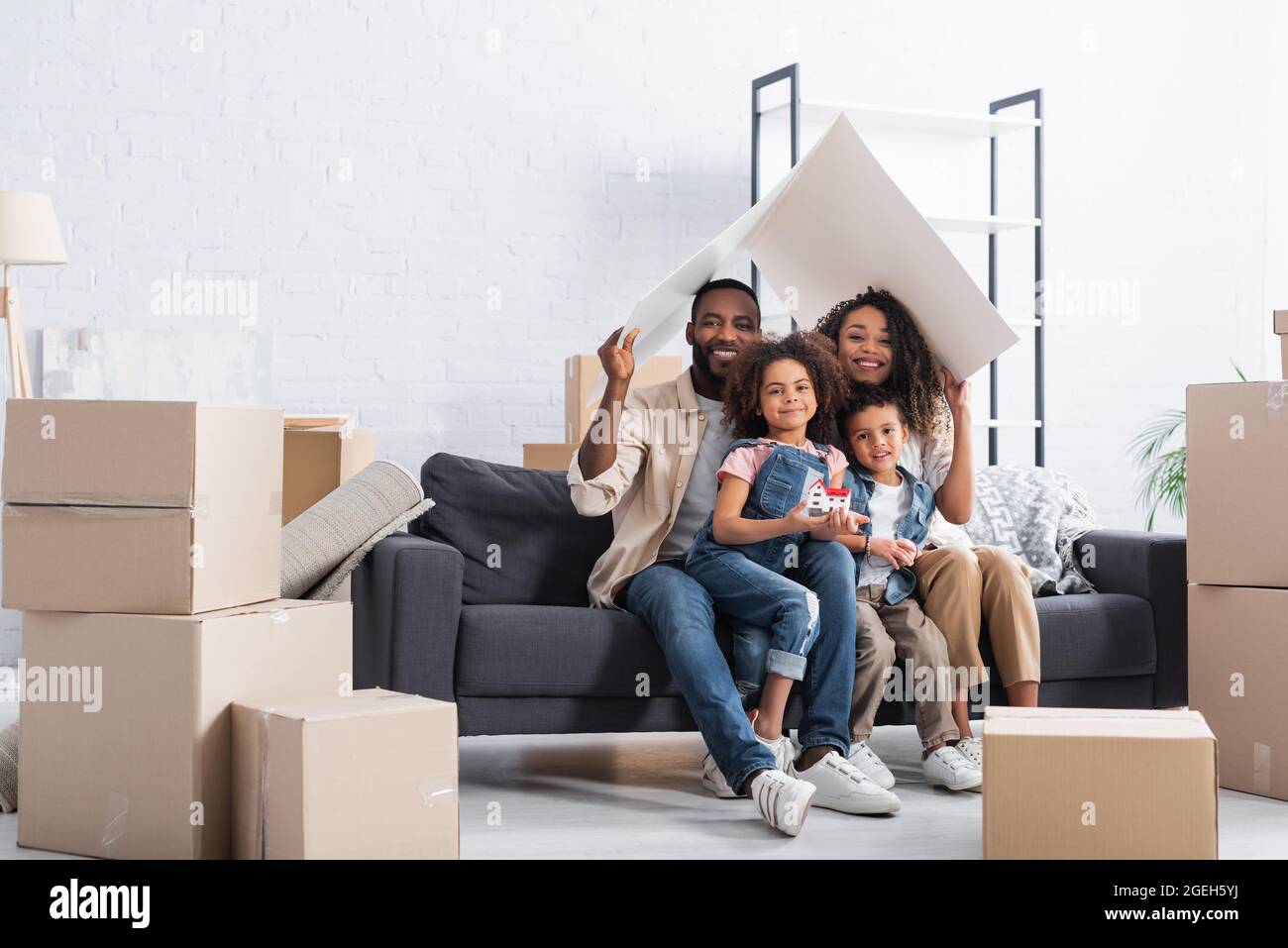 african american couple sitting under paper roof on sofa Stock Photo ...