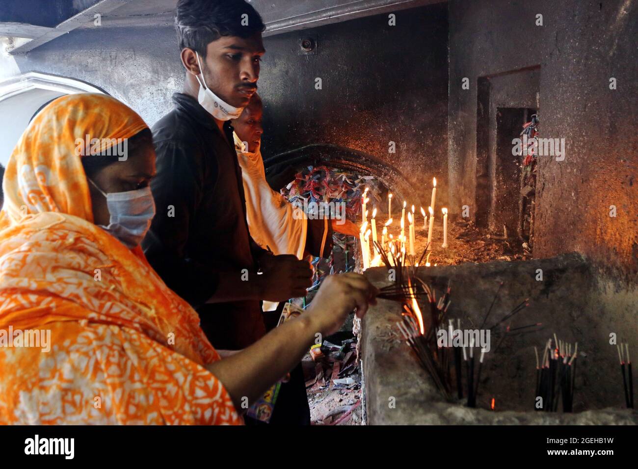 Non Exclusive: DHAKA, BANGLADESH - AUGUST 20: A shia woman  lights a candle during  the day of mourning to commemorate Ashura Day. The tenth day of Mu Stock Photo