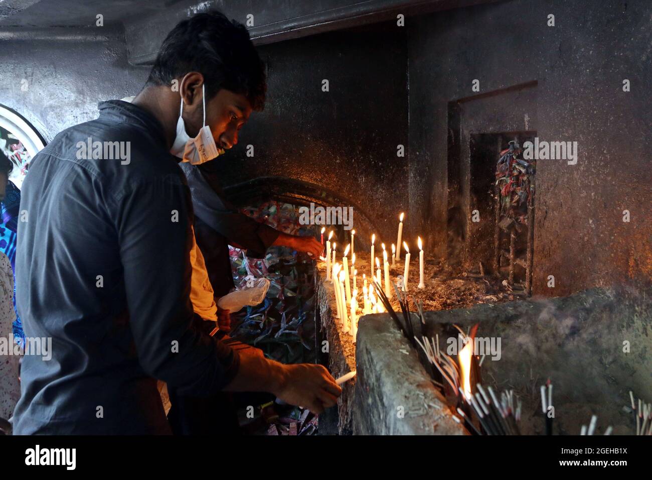 Non Exclusive: DHAKA, BANGLADESH - AUGUST 20: A shia man  lights a candle during  the day of mourning to commemorate Ashura Day. The tenth day of Muha Stock Photo