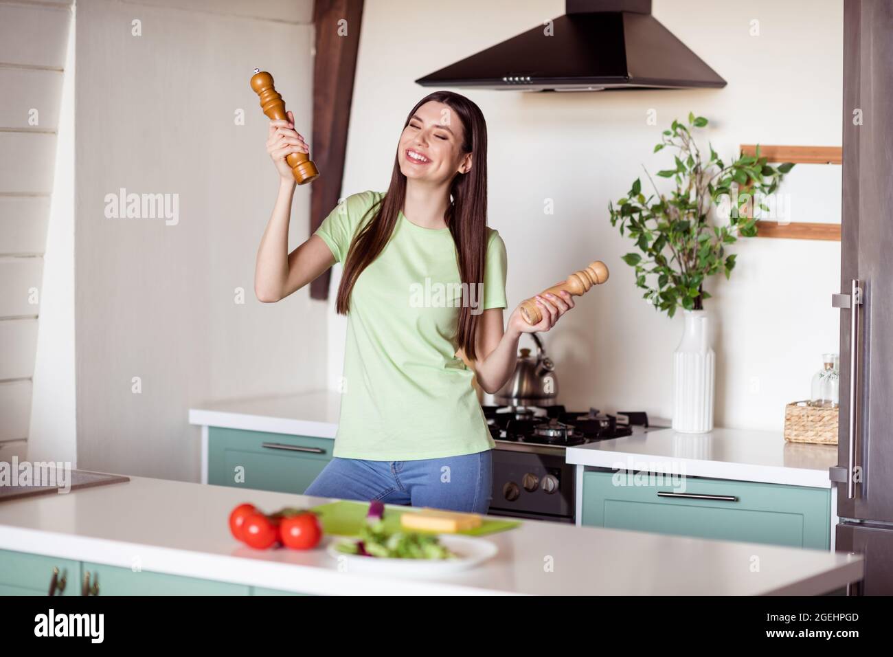 Photo of funny friendly young lady cook kitchen wear green t-shirt at kitchen home alone Stock Photo