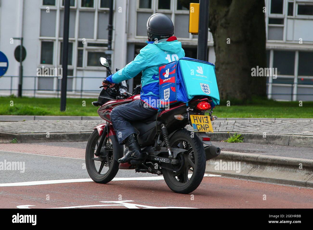 A Deliveroo takeaway food delivery motorcycle rider with food delivery
