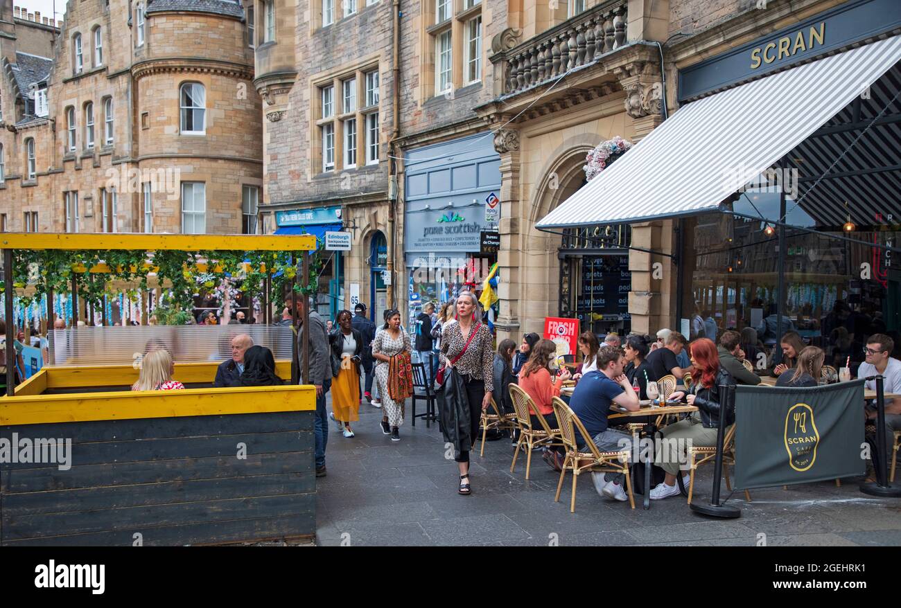 Edinburgh, Scotland, UK weather. 20 August 2021. Cloudy day for city centre and those seeking some enterainment from the various festivals in the city. Pictured: diners and passersby on Cockburn Street. Credit: Arch White/Alamy Live News Stock Photo