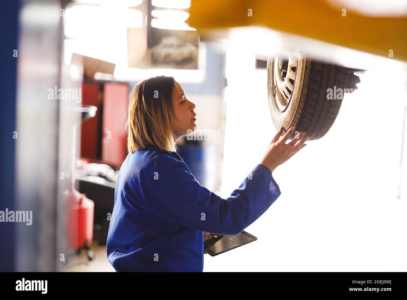 Mixed race female car mechanic wearing overalls, inspecting car Stock Photo Alamy