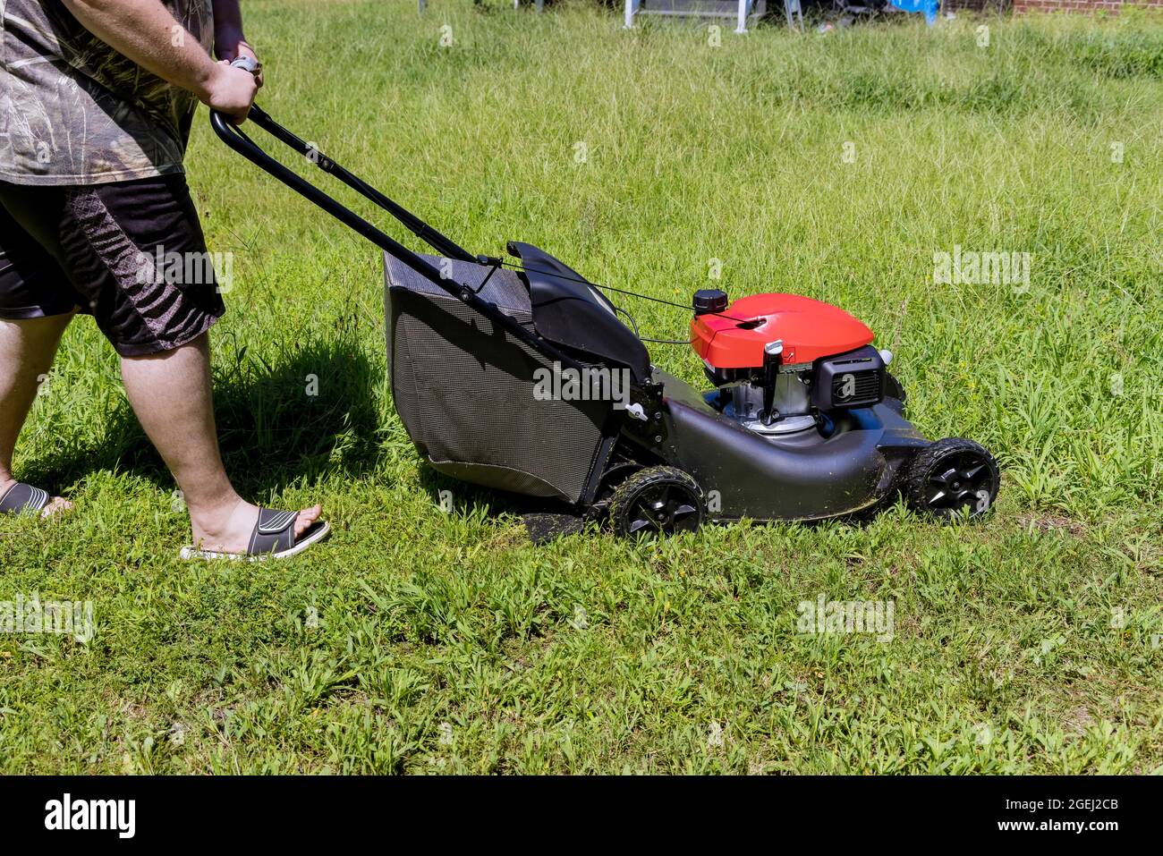 Working lawn mower on green lawn with trimmed grass in garden care work tool Stock Photo