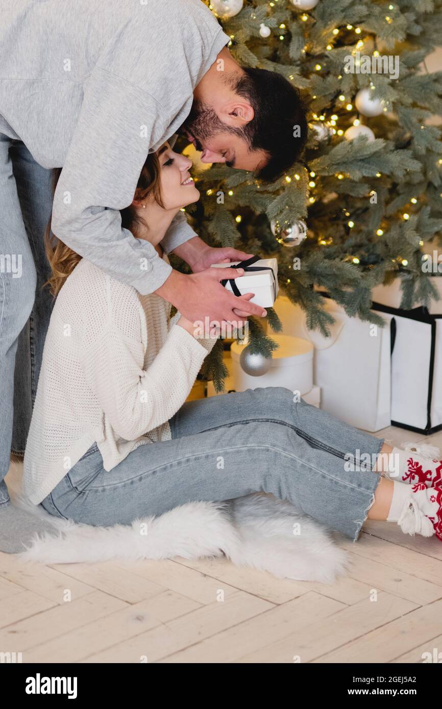 Man giving box with Christmas present to his girlfriend. Stock Photo