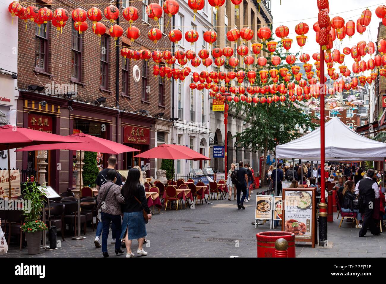 LONDON WESTMINSTER CHINATOWN SHOPS SUPERMARKET AND OUTDOOR EATING AREA WITH CAFES AND PEOPLE Stock Photo