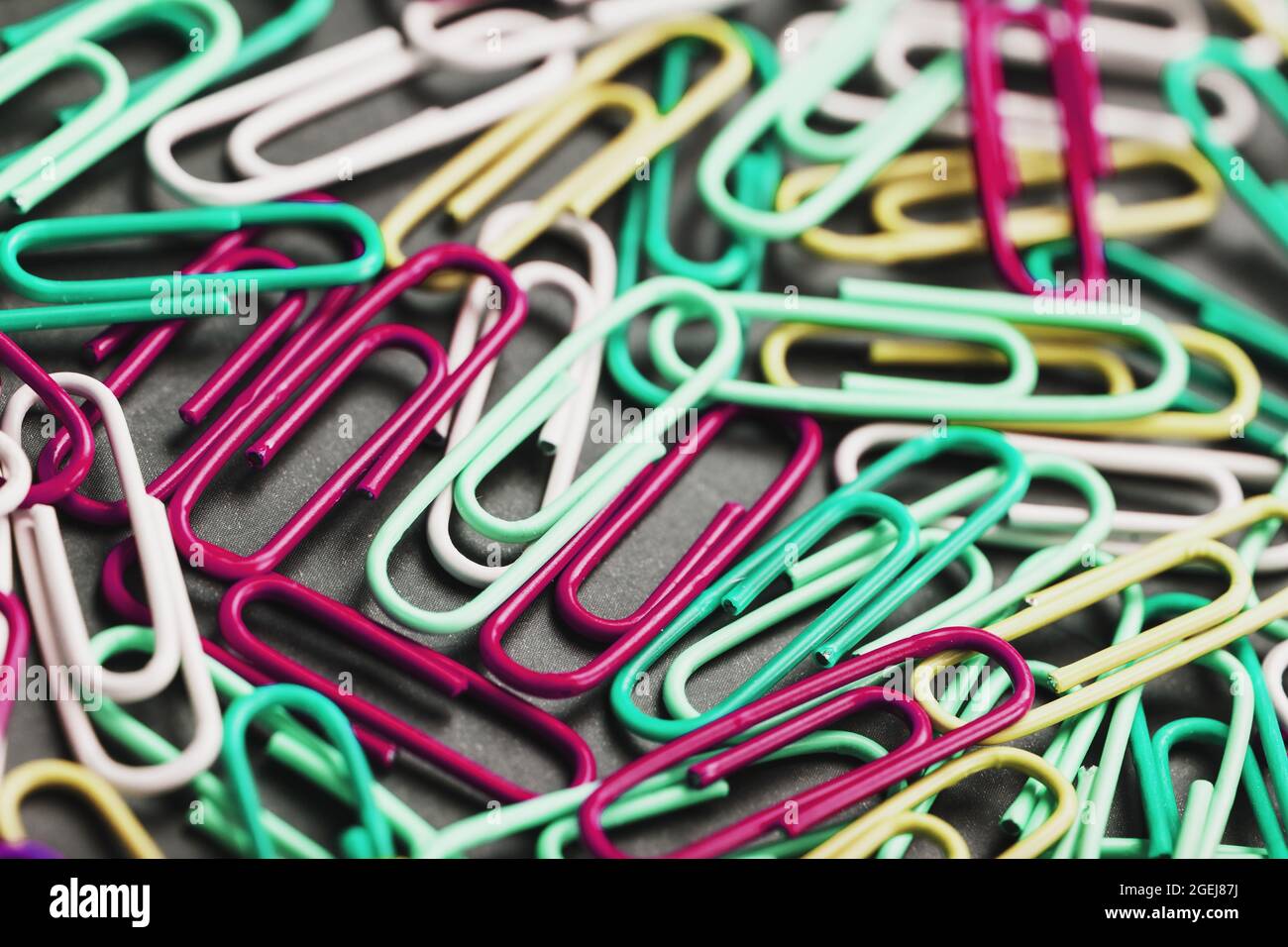 Colored paper clips textured background, full screen Stock Photo