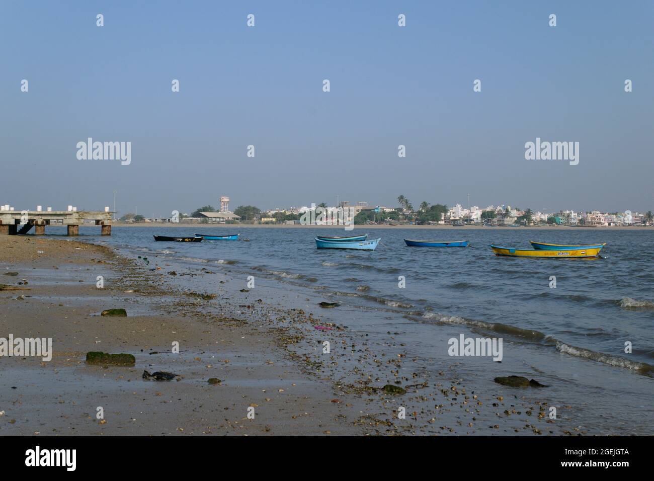 Many small colorful boats are anchored at a sandy beach in the port city of Diu India in the Arabian sea. Stock Photo