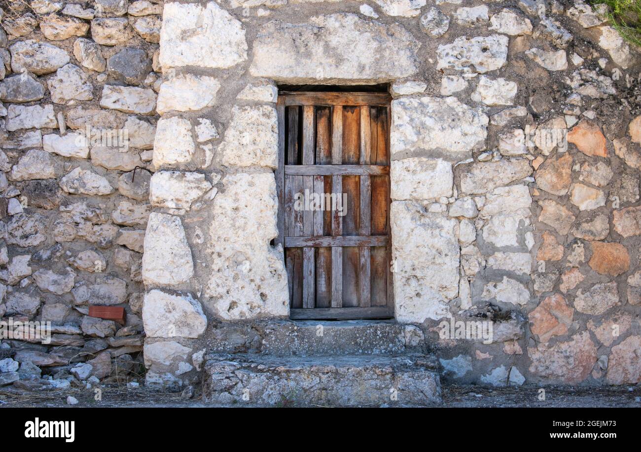 Facade of an old stone building with a wooden door Stock Photo - Alamy