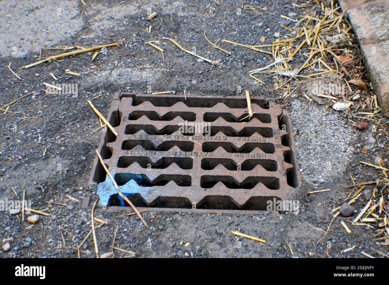 Drain covering with a blue dot of spray paint on the corner indicates