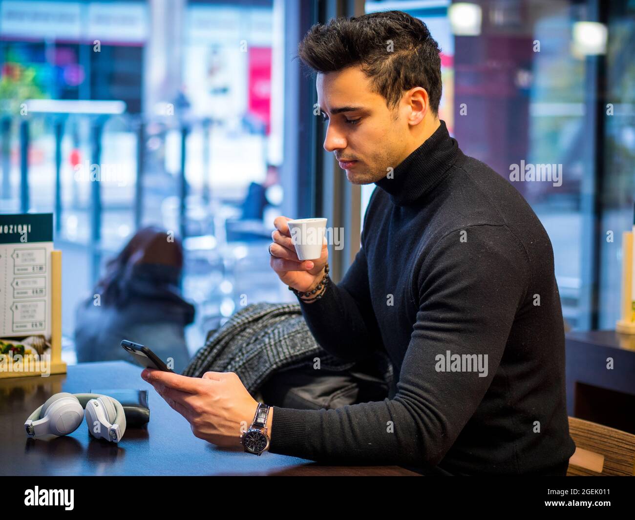 Attractive Man Drinking Coffee and Using Smartphone Stock Photo
