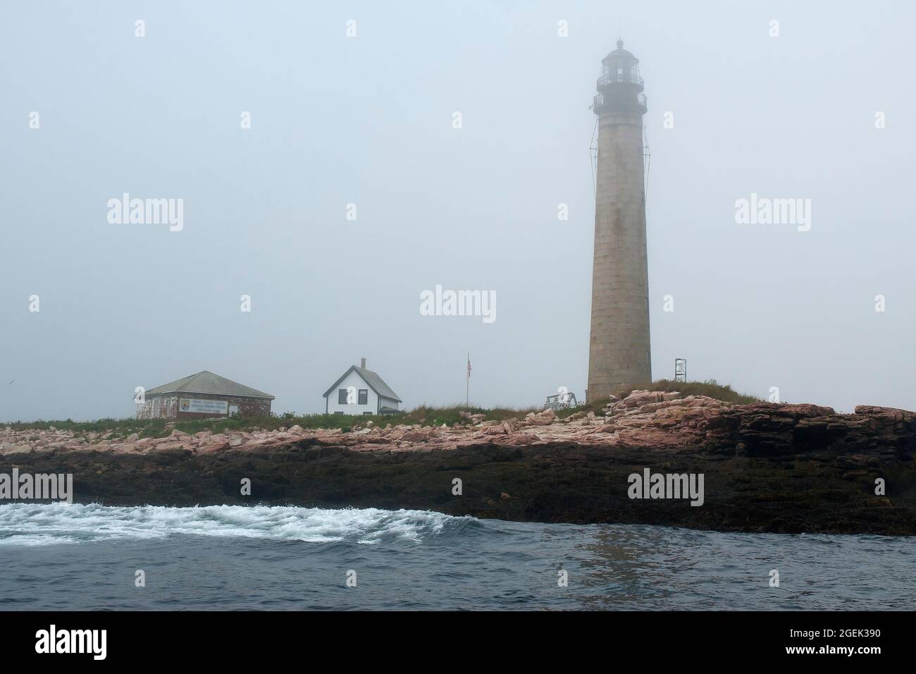 Sun starts to break through fog at Petit Manan lighthouse, a rocky island beacon that is the second tallest lighthouse in Maine. Stock Photo