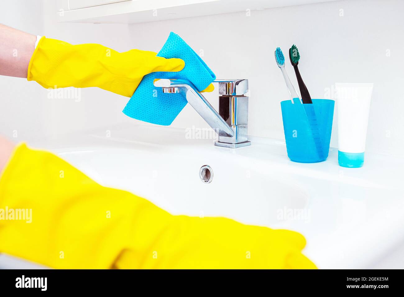 Woman doing chores in bathroom, cleaning of water tap or sink and