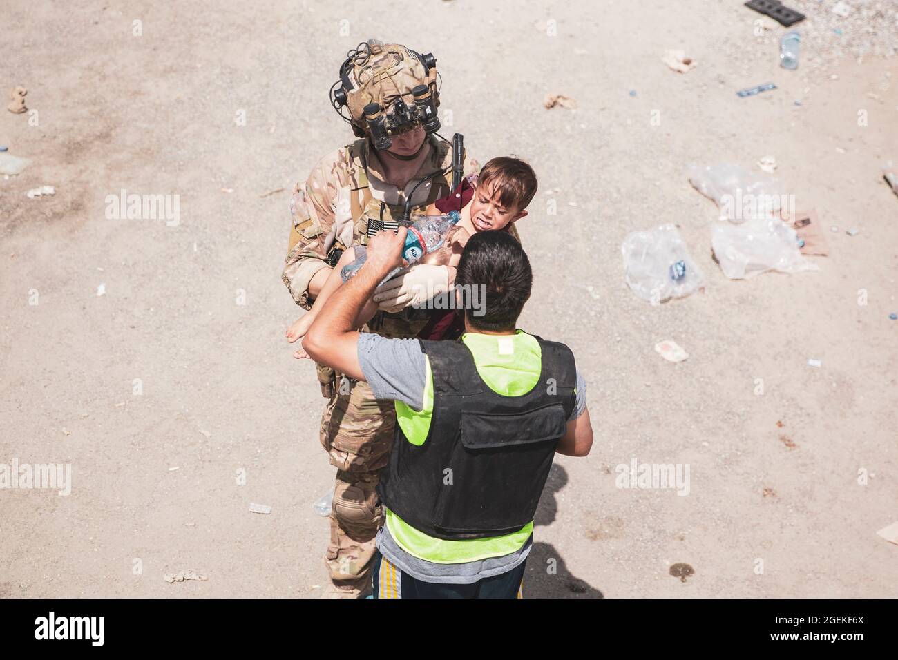 Kabul, Afghanistan. 20th Aug, 2021. A British soldier takes an unaccompanied child from an aid worker during the evacuation of non-combatants at Hamid Karzai International Airport, part of Operation Allies Refuge August 20, 2021 in Kabul, Afghanistan. Credit: Planetpix/Alamy Live News Stock Photo