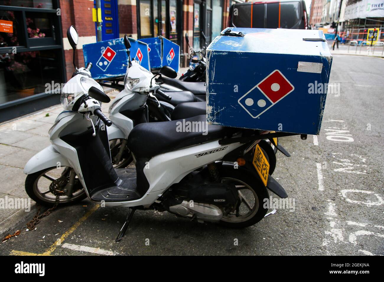 Bristol, UK. 16th Aug, 2021. Domino's Pizza delivery scooters seen in
