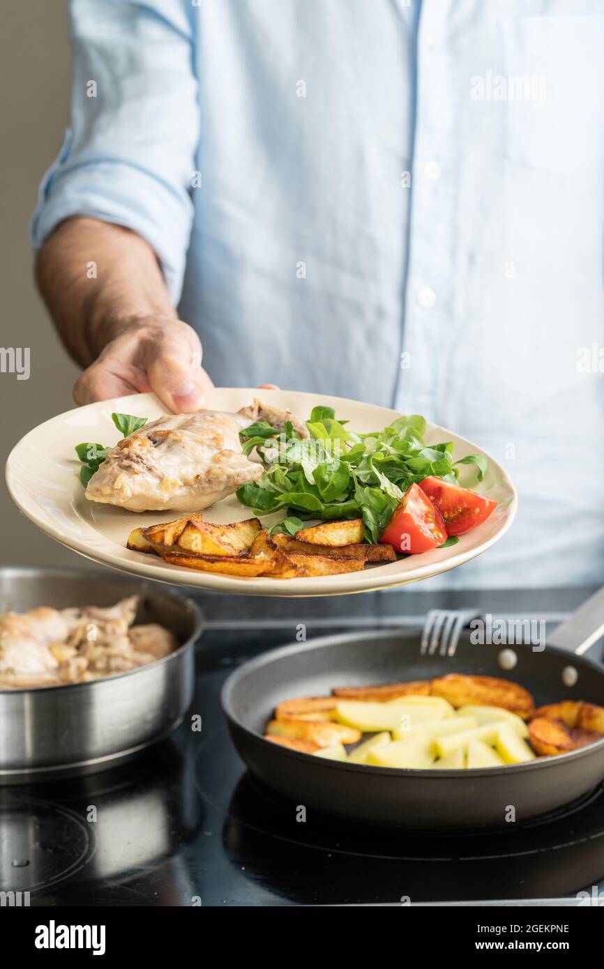 The hands of a man cook potatoes in a frying pan. Family dinner Stock