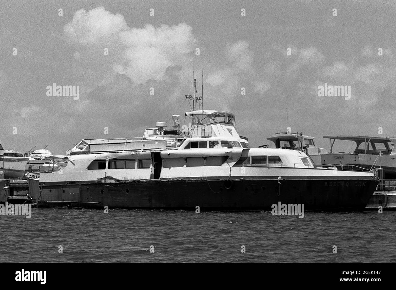 AJAXNETPHOTO. MAY, 1981. KEY WEST, FLA, USA. - IMPOUNDED MARIEL BOAT - REEF QUEEN, ONE OF THE MORE THAN 1,400 BOATS USED IN THE CUBAN MARIEL BOAT-LIFT ESCAPING REFUGEE EXODUS BETWEEN APRIL AND OCTOBER 1980 FROM CUBA TO THE FLORIDA KEYS AFTER BEING IMPOUNDED BY U.S. COASTGUARD AND CUSTOMS IN THE HARBOUR. REEF QUEEN SUFFERED DAMAGE TO HULL AND UPPERWORKS. THE BOATS BROUGHT APPROXIMATELY 125,000 FLEEING CUBANS TO THE USA.PHOTO:JONATHAN EASTLAND/AJAX REF:812805 19A 51 Stock Photo