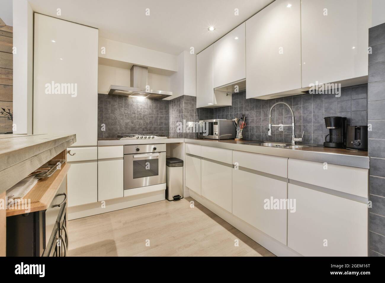 Modern kitchen interior with white furniture and gray tiles Stock Photo ...