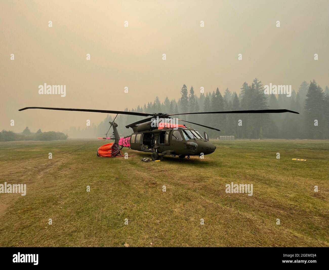 A U.S. Army UH-60 Black Hawk helicopter flown by the California Army National Guard is positioned at the Battle Creek helibase near Mineral, California, Aug. 17, 2021, while fighting the Dixie Fire. The fire eclipsed 600,000 acres and is currently the second-largest fire in California’s recorded history. (U.S. Army National Guard photo by 1st Lt. Rockne Harmon) Stock Photo