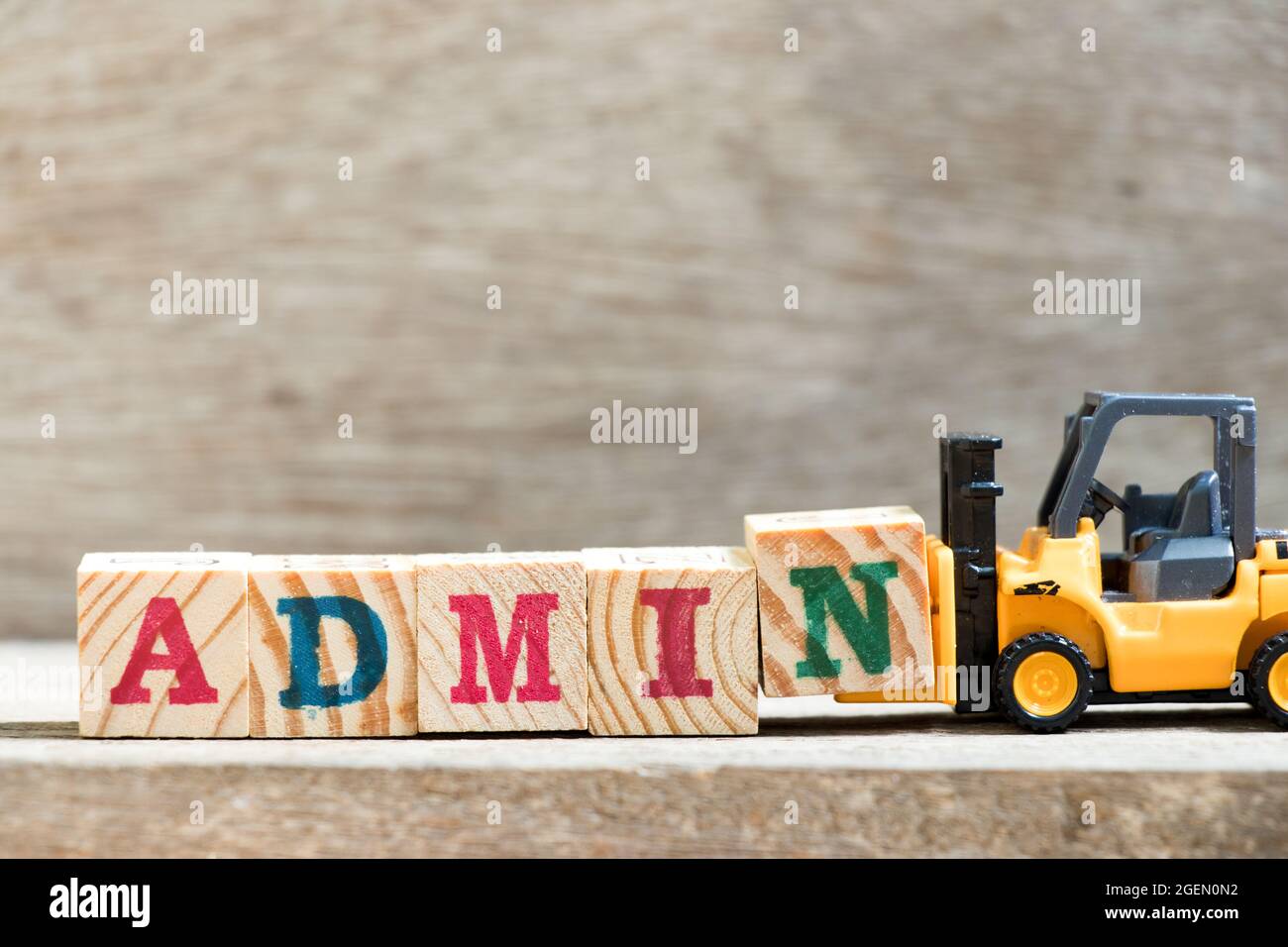 Toy forklift hold letter block N in word admin on wood background Stock Photo