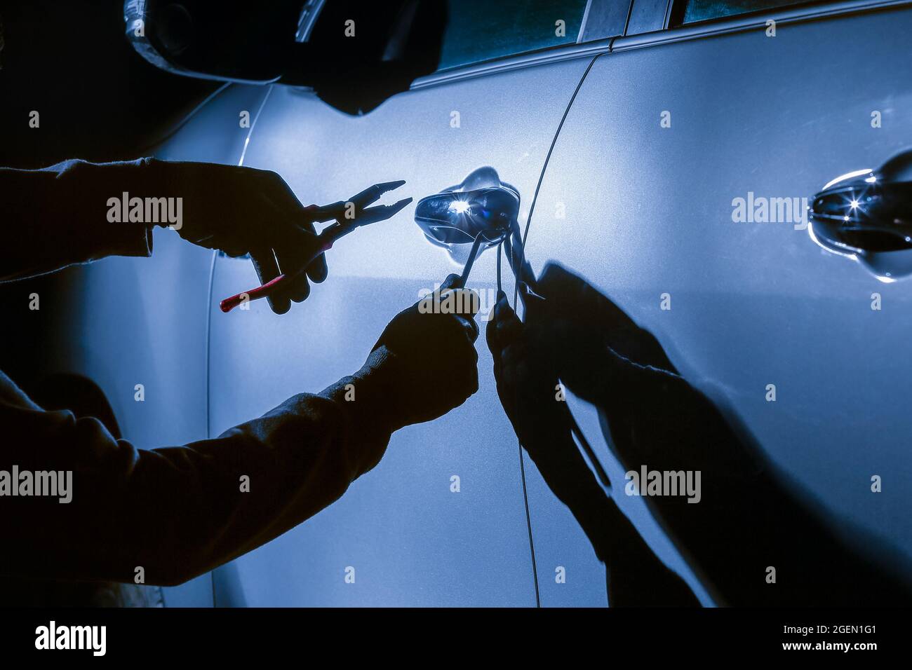 Car thief using a tool to break into a car Stock Photo Alamy