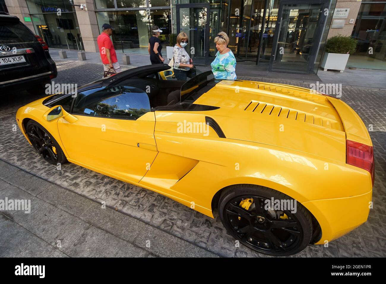Bucharest, Romania - August 17, 2021: An yellow 2006 Lamborghini Gallardo Spyder is parked in front of the entrance to the Radisson Blu Hotel Buchares Stock Photo
