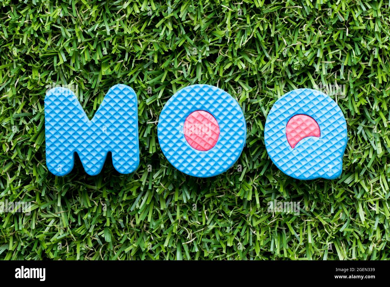 Color alphabet letter in word MOQ (Abbreviation of Minimum Order Quantity) on artificial green