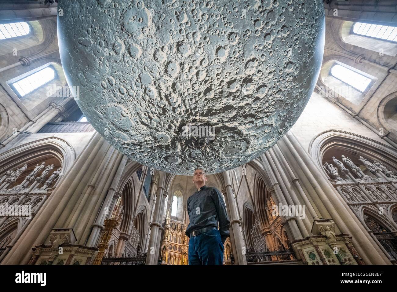Resident Vicar, James Heard, stands with Museum of the Moon installation by artist Luke Jerram at St.John the Baptist church in west London, UK. Stock Photo