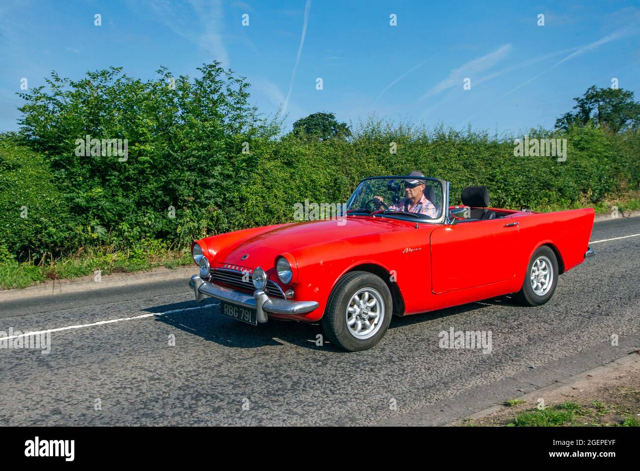 1963 60s sixties red Sunbeam Alpine two-seater sports drophead coupé 1582cc Cabrio en-route to Capesthorne Hall classic July car show, Cheshire, UK Stock Photo
