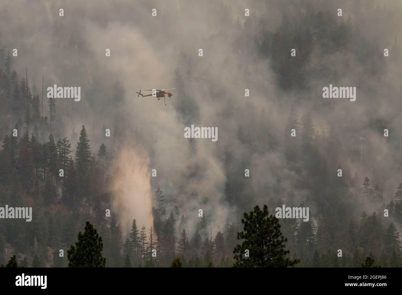 Milford, United States. 20th Aug, 2021. A helicopter drops water on the Dixie fire. A spot fire from the Dixie Fire spreads to the highway 395. Cal Fire reports that the Dixie Fire has now grown over 700,000 acres. The cause of the fire is still being investigated. (Photo by Ty O'Neil/SOPA Images/Sipa USA) Credit: Sipa USA/Alamy Live News Stock Photo