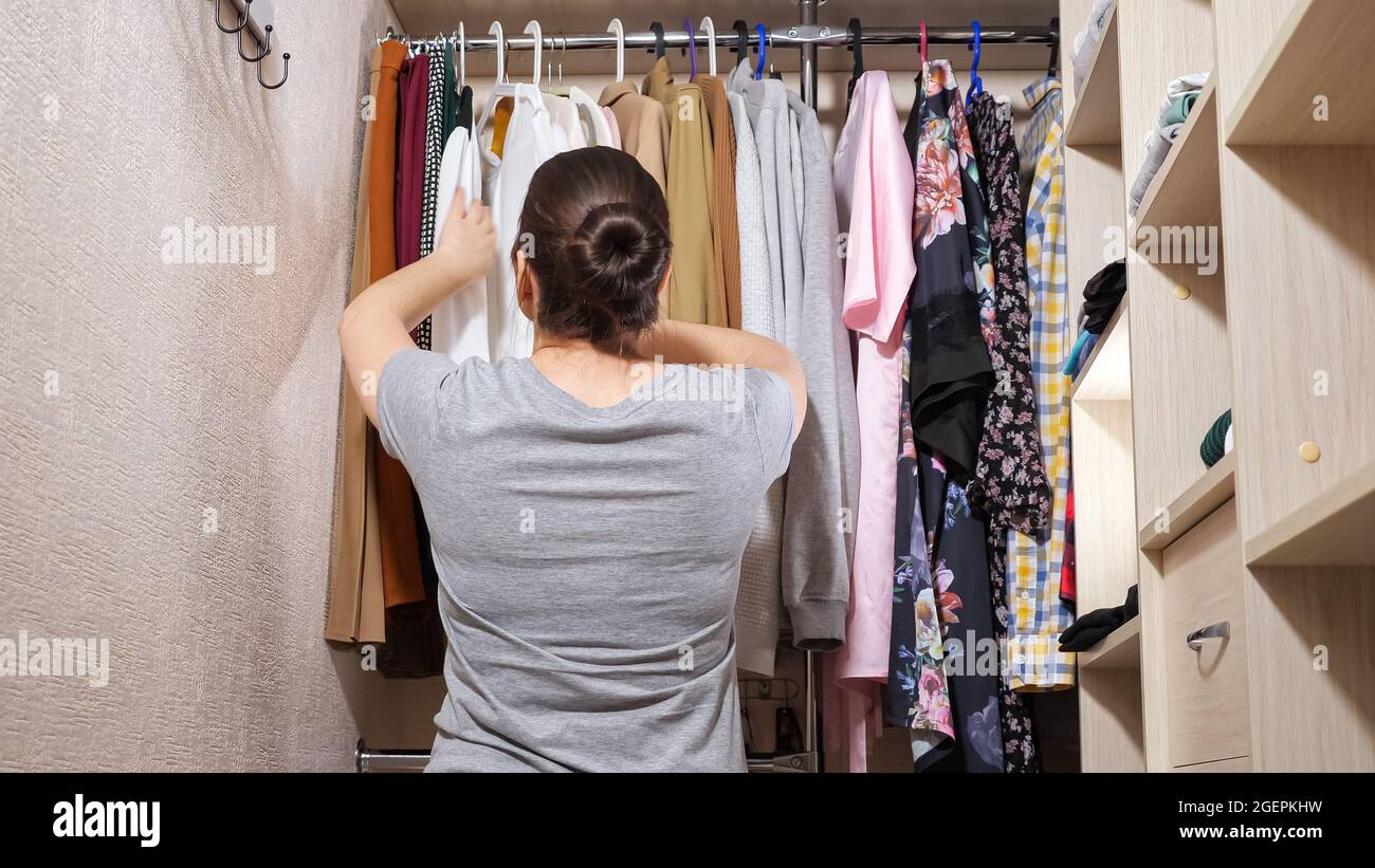 https://c8.alamy.com/comp/2GEPKHW/young-woman-chooses-clothes-in-contemporary-walk-in-closet-2GEPKHW.jpg