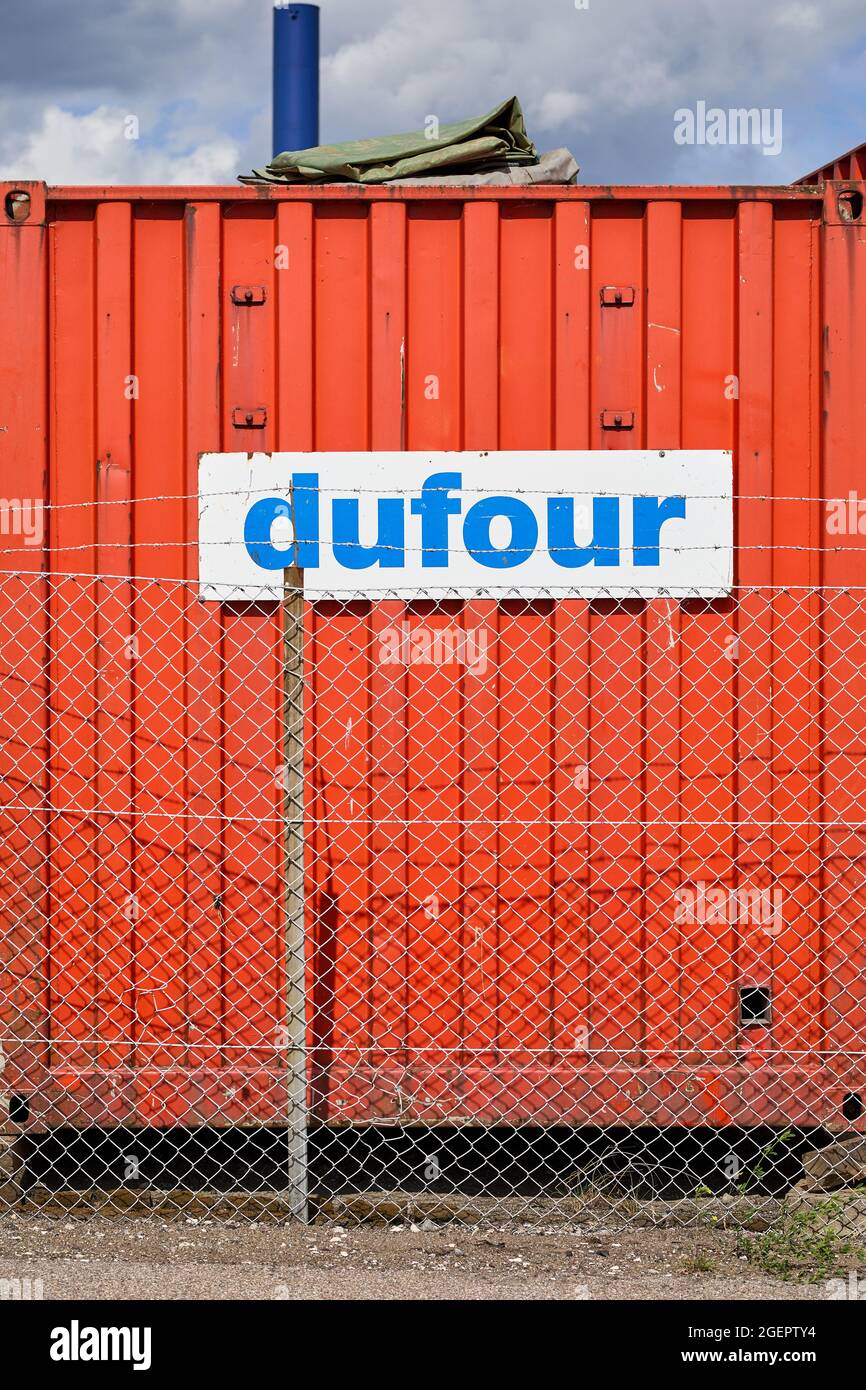Dufour, sign on shipping container behind fence Stock Photo