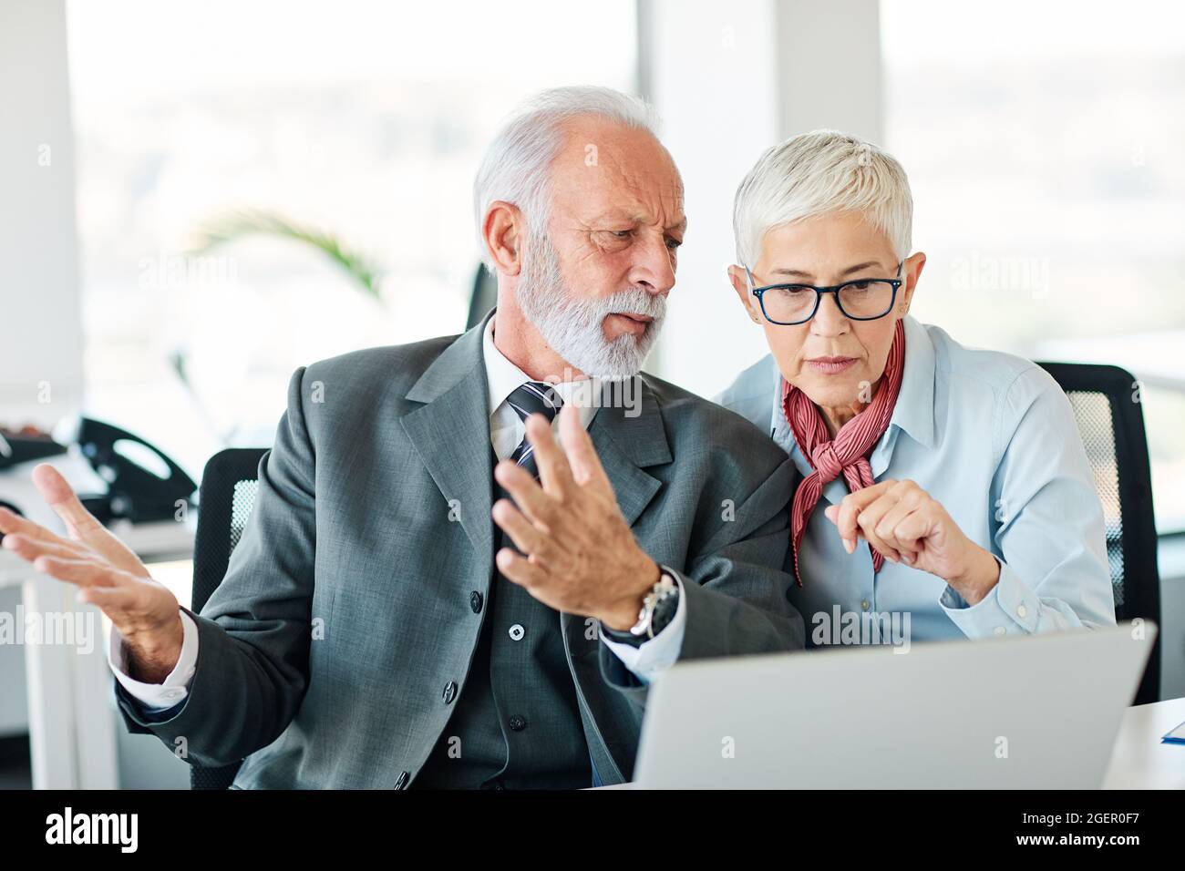 business office person discussion laptop problem worried teamwork senior meeting Stock Photo