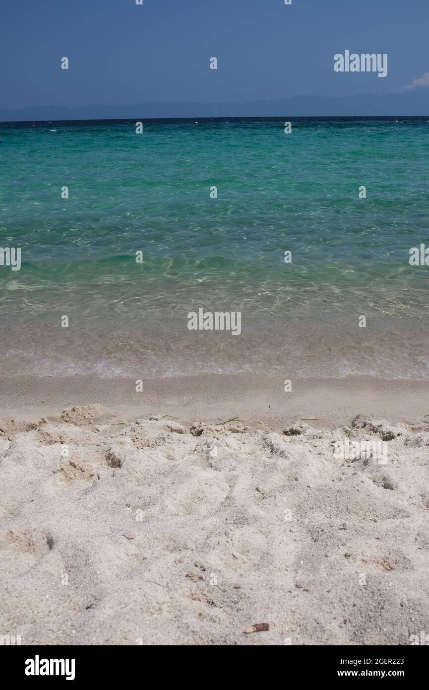 Close up of a the beautiful sandy beach with white foamy waves  of Armenistis in Halkidiki Greece Stock Photo