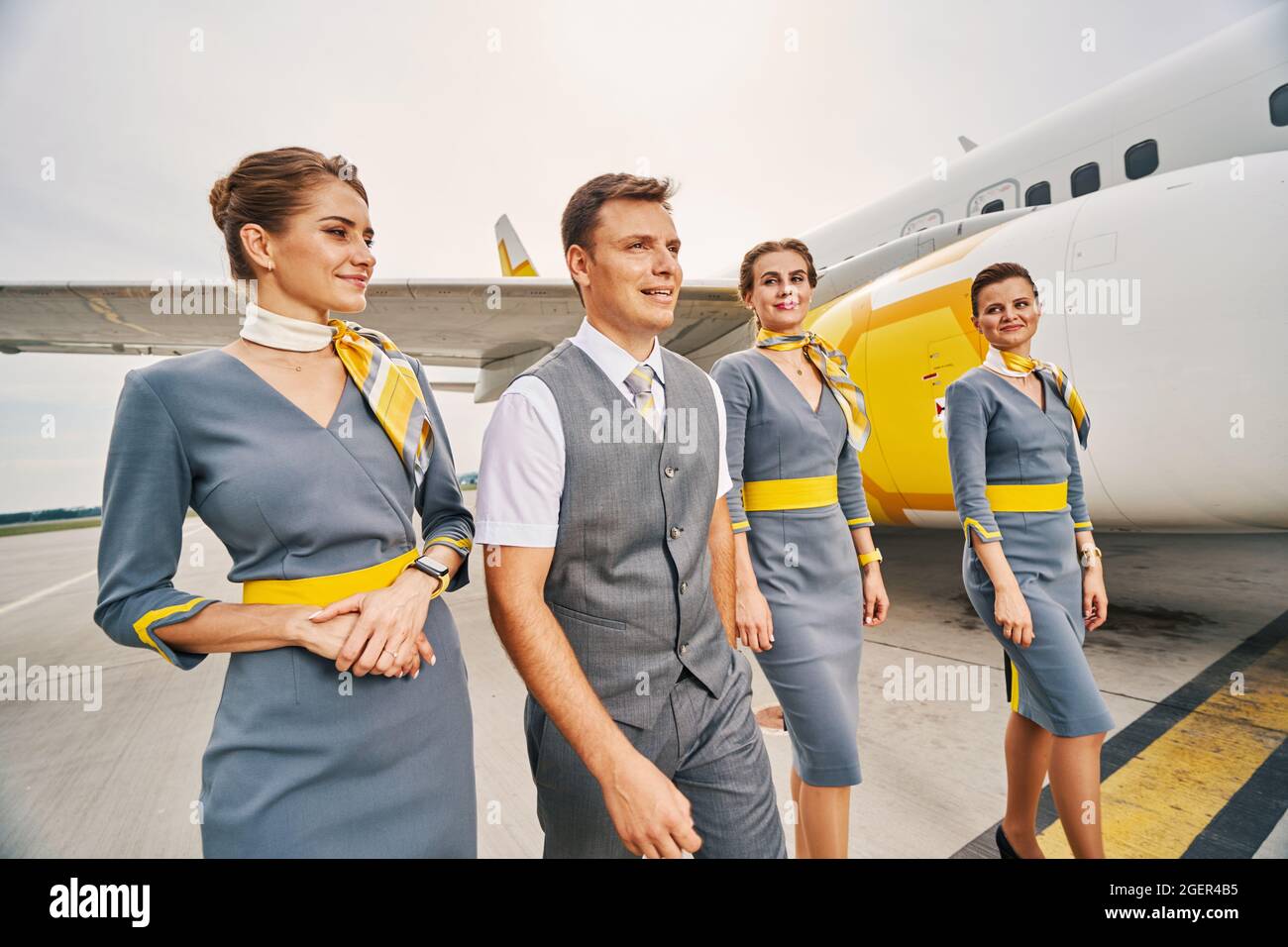 Four attractive aircrew members standing by a landed aircraft Stock Photo -  Alamy