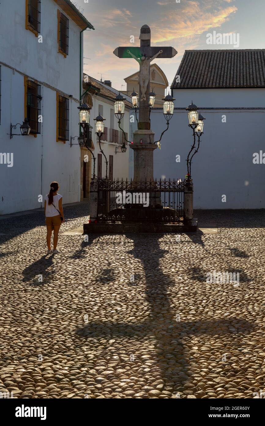 Girl contemplating the Christ of the Lanterns at sunset in the Plaza de Capuchinos in Cordoba Andalusia Spain Stock Photo