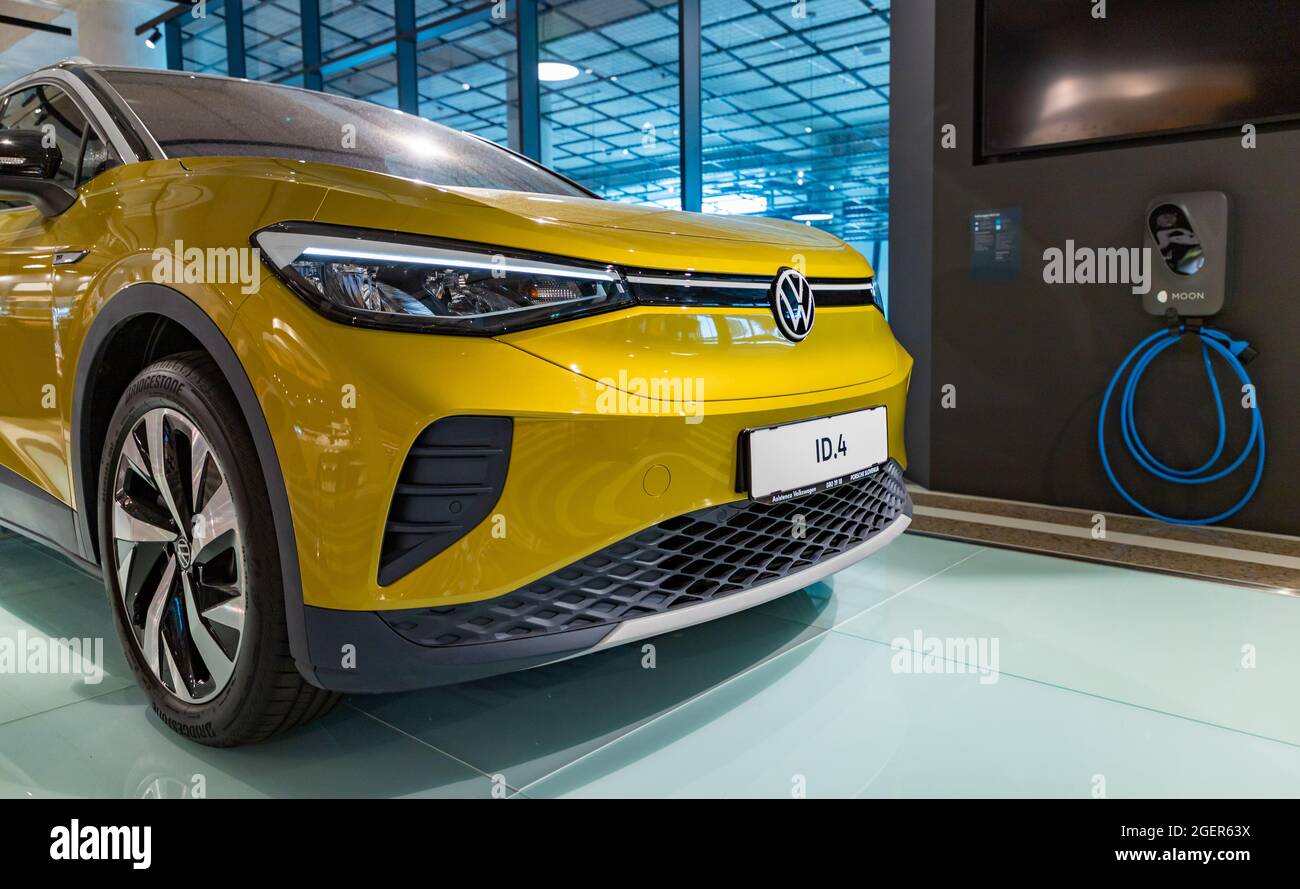 A picture of a yellow Volkswagen ID.4 next to a charging station. Stock Photo