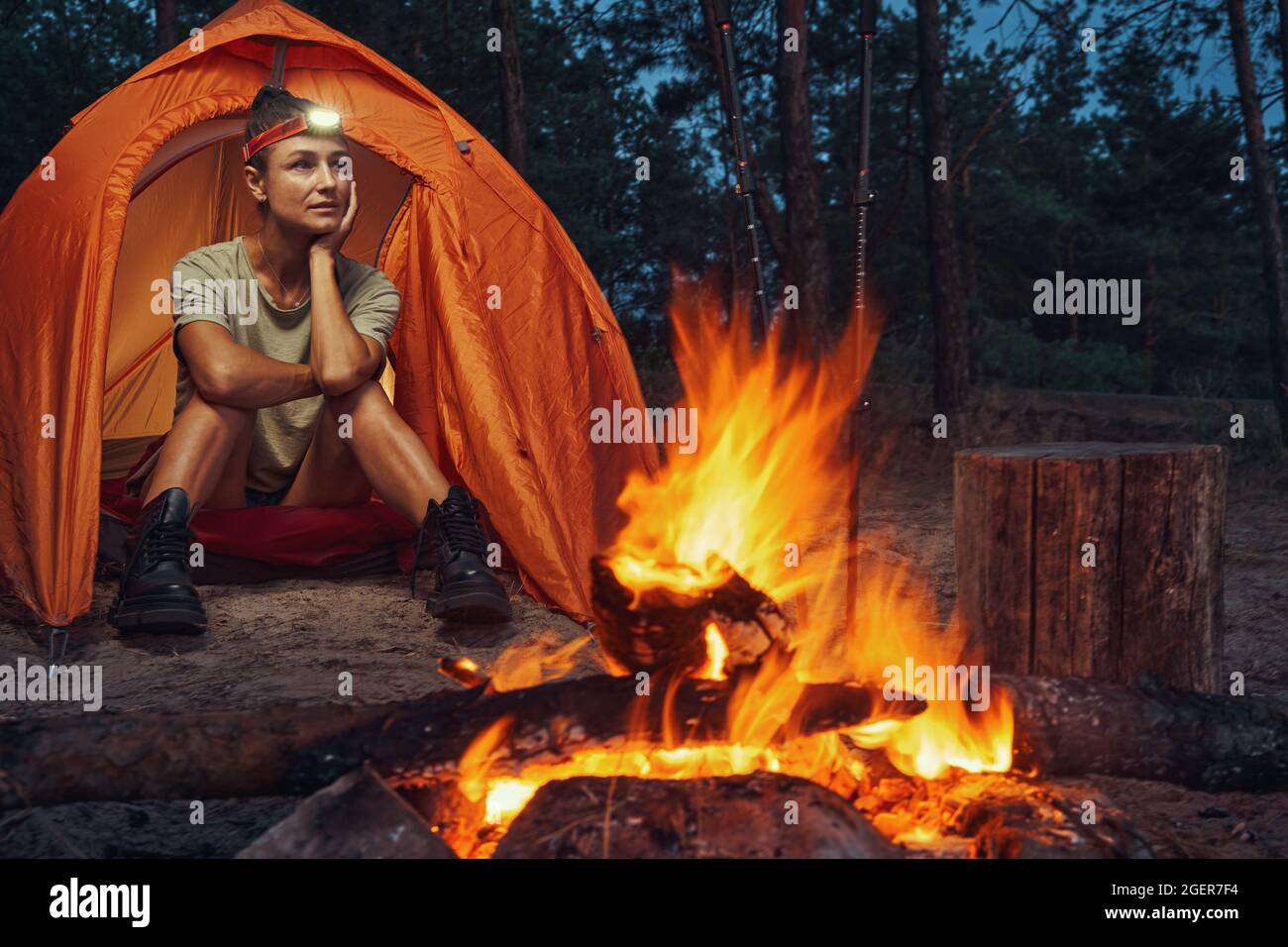 Female camper enjoying night in the forest Stock Photo