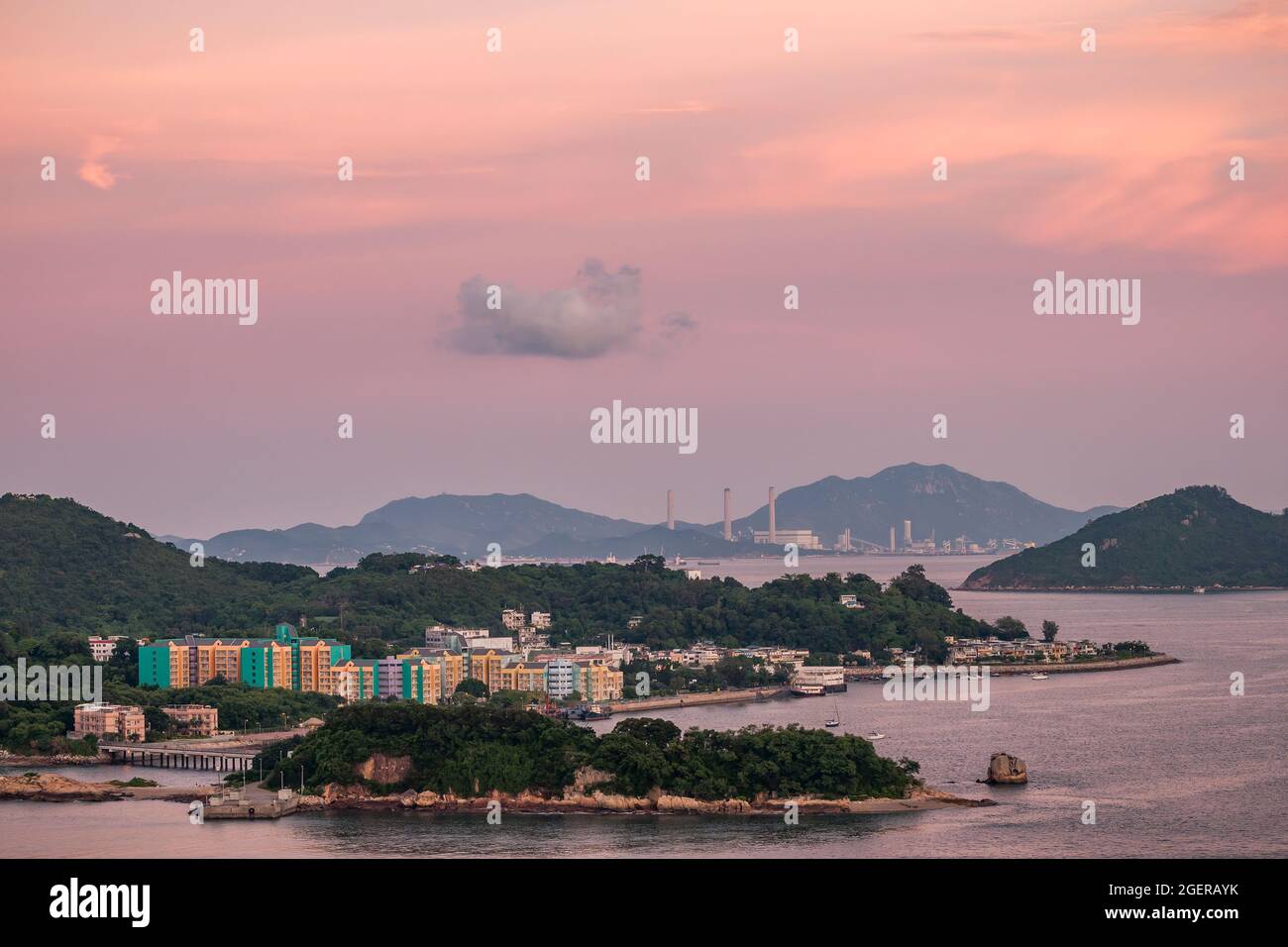 Sunset tinges the clouds above Peng Chau, Chau Kung To (Sunshine Island) and Lamma Island, Hong Kong, in the pink light of sunset Stock Photo