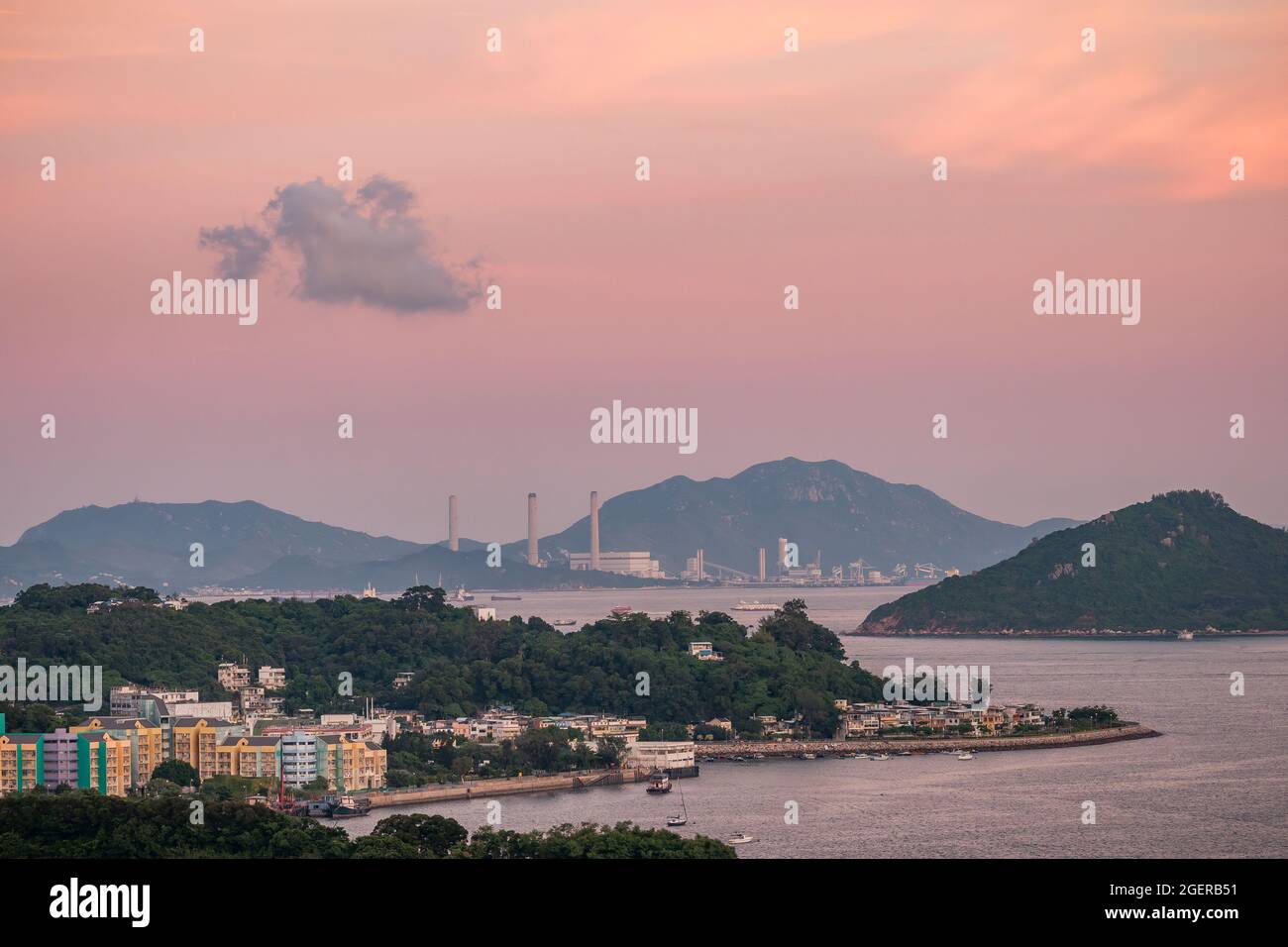 Sunset tinges the clouds above Peng Chau, Chau Kung To (Sunshine Island) and Lamma Island, Hong Kong, in the pink light of sunset Stock Photo