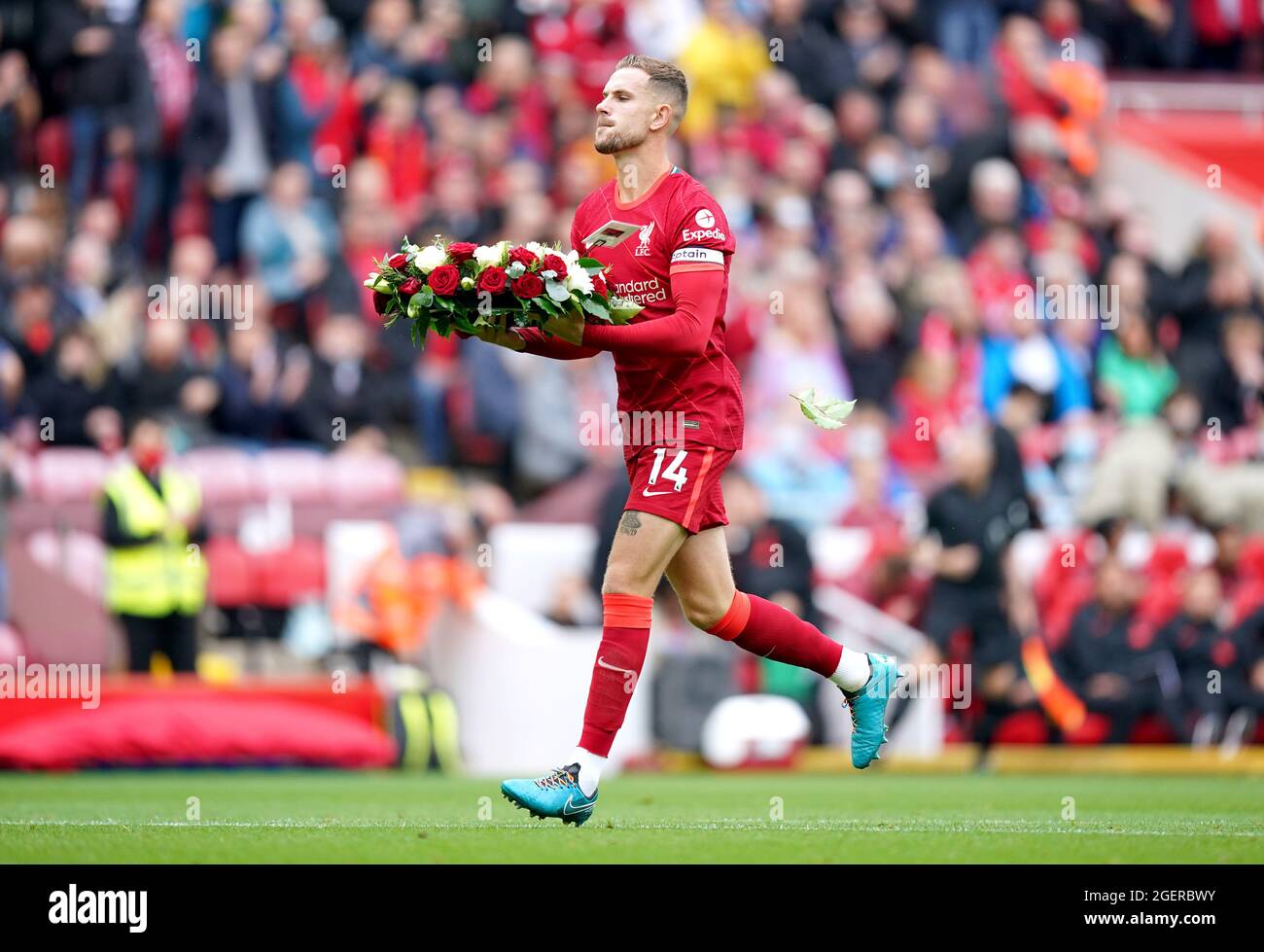 Liverpool's Jordan Henderson carries a wreath in memory of Andrew ...