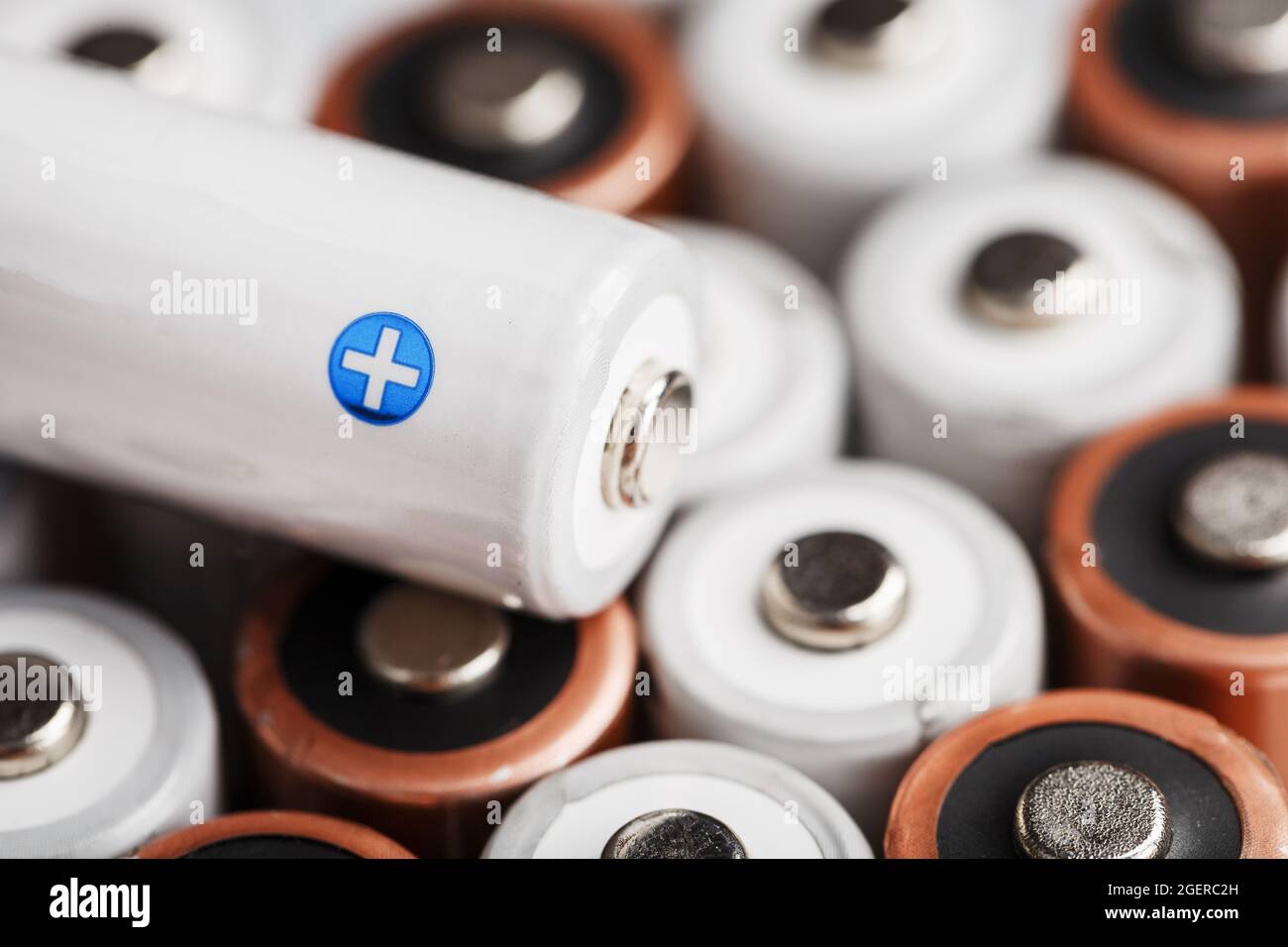AA rechargeable batteries with a white battery with a positive polarity. Selective focus Stock Photo