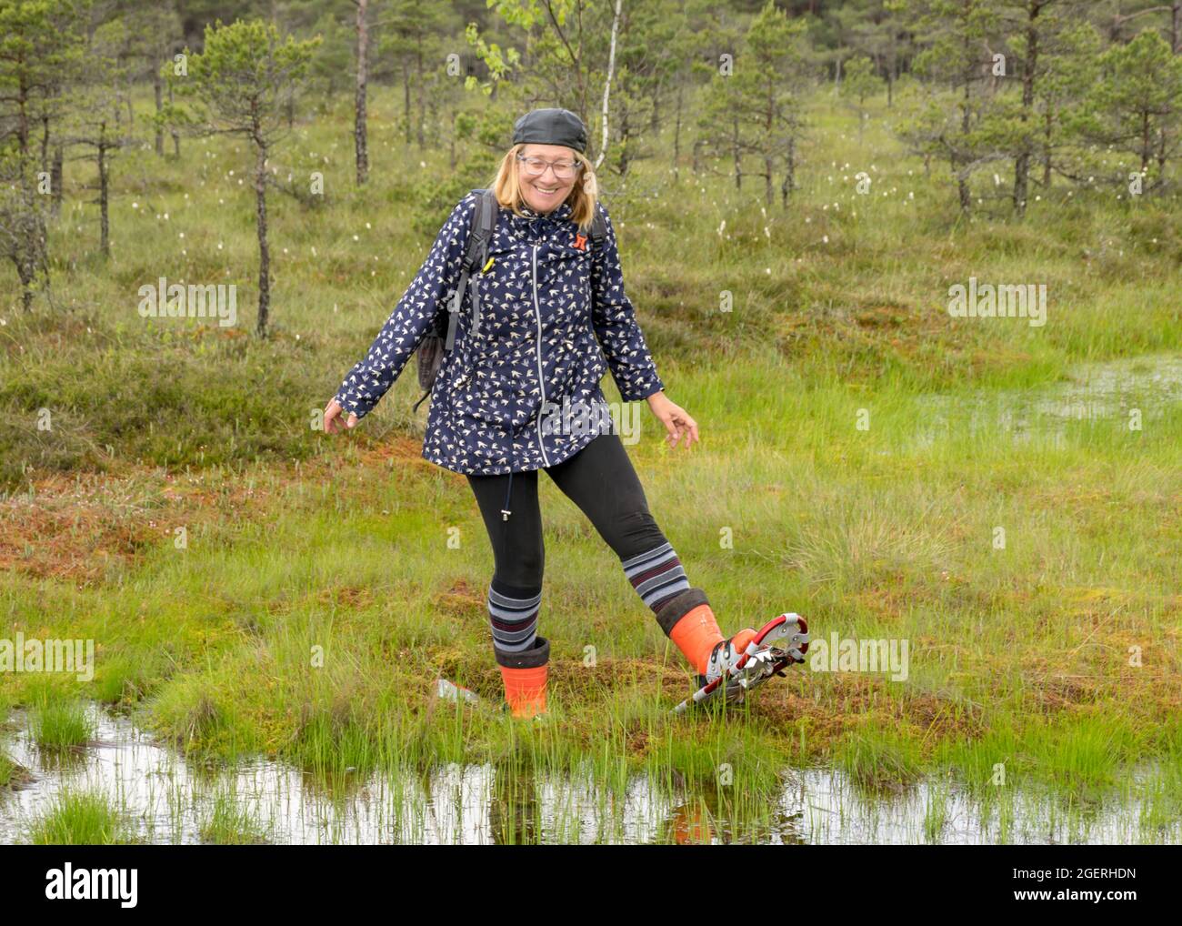 happy woman enjoys swamp scenery, hike in the swamp with snowshoes, traditional mire plants, swamp background, bog texture in summer Stock Photo