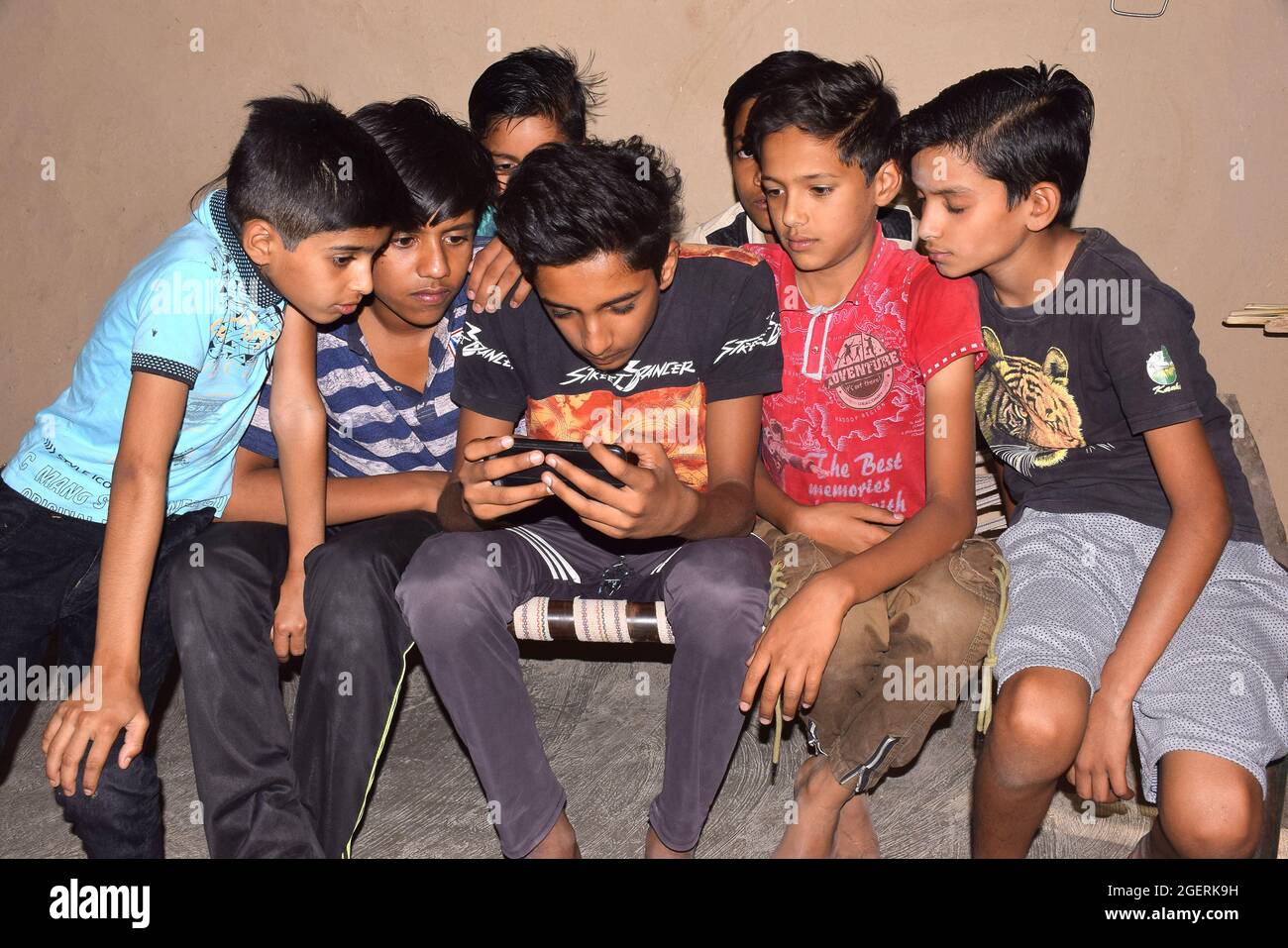 20-05-2020,Bhadapipalya, Madhya Pradesh, India, Indian rural children sitting on the bed and playing games on mobile phones Stock Photo